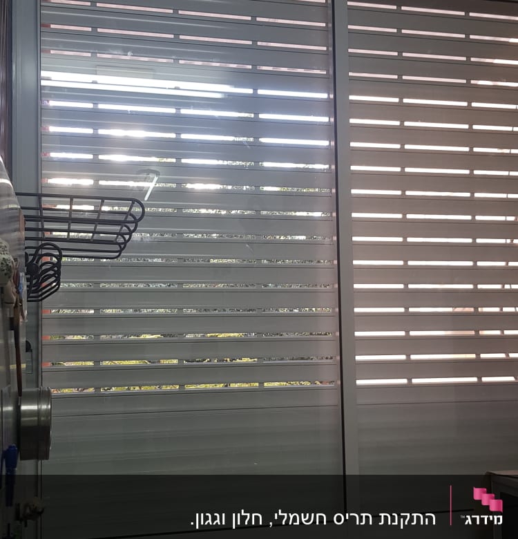 תריסי אלומיניום בחלון גדול עם מסגרת לבנה